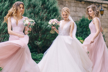 beautiful bride with her girlfriends dance fun in a beautiful white dress, girls in pink