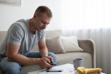 Serious male calculating taxes at home