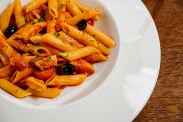 Spaghetti pasta with tomatoes and parsley on wooden table