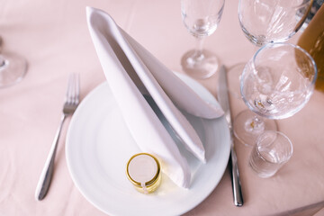 silverware and plates with silk napkins on a pink tablecloth.