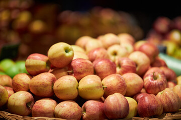 ripe apples on the counter in the store. Red and green apples on the market counter. Apples on the grocery shelf. ripe, juicy green apples in a wicker basket on a shop counter, market. harvesting. 