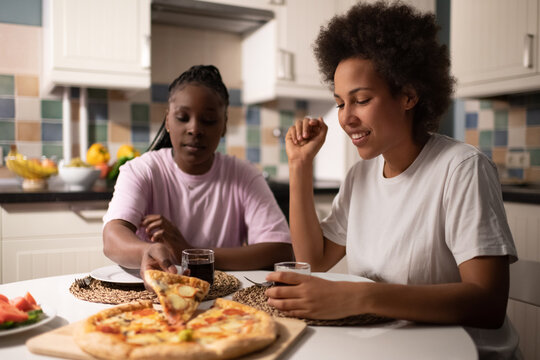 Multiracial women eating pizza together