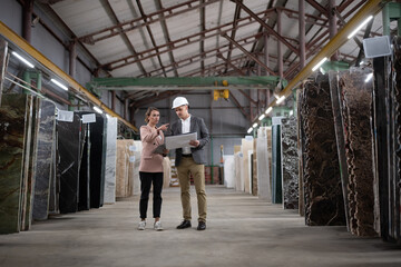 Workers discussing marble in warehouse