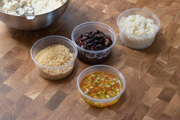 Typical brazilian food take away, white rice, beans, vinaigrette, farofa