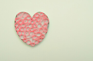 A paper heart on light green background