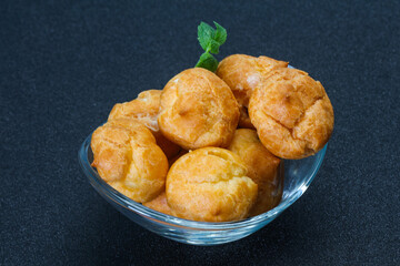 Sweet tasty profiteroles heap in the bowl