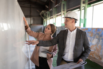 Workers examining marble slab in modern storehouse
