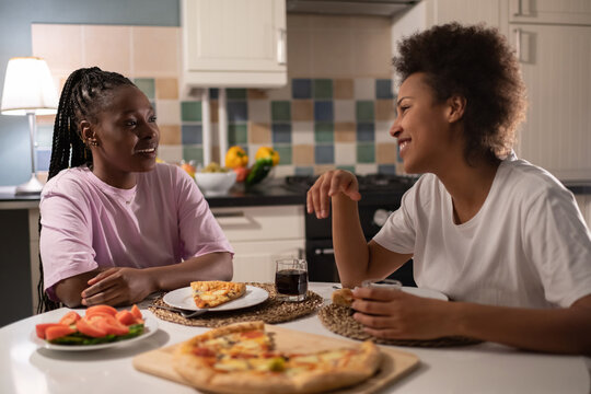Multiethnic friends talking during pizza time