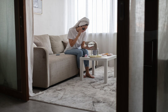 Woman doing skin care routine on couch