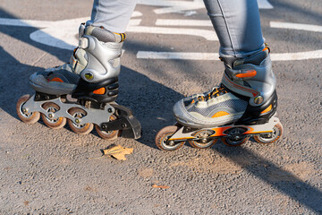 Active leisure. A sportive girl is rollerblading in an autumn park
