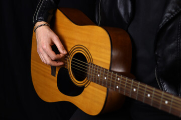 hand of a man playing acoustic guitar close up