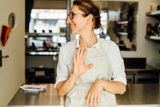 Female chef making gestures while standing at restaurant kitchen