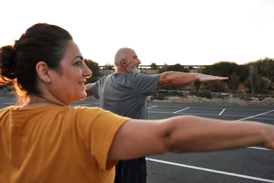 An Older Couple Practices Yoga Outdoors.