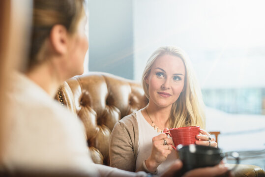 Attentive female listening to girlfriend in cafe