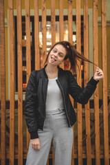 Fototapeta premium A young woman with a high ponytail is standing and fooling around