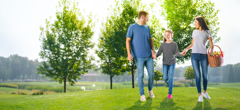 Group portrait of going on picnic young family, countryside or park. Happy childhood and summertime concept image. Copy space empty place for some text. Sunny day picture.