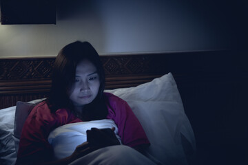 Asian woman playing game on smartphone in the bed at night,Thailand people,Addict social media