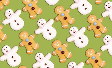 Christmas cookies pattern in the shape of a snowman and a gingerbread man decorated with icing sugar and fondant on a green background