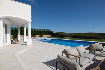 Large swimming pool in the garden of a luxury villa on the algarve with ceramic tiled surround and seating area