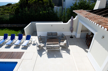 High angle view of a patio seating area by the pool in the garden of a holiday villa