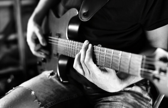 male guitarist playing electric guitar. black and white