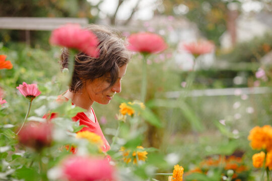 A woman stands half-hidden in beautiful patch of wildflowers in summer - Powered by Adobe