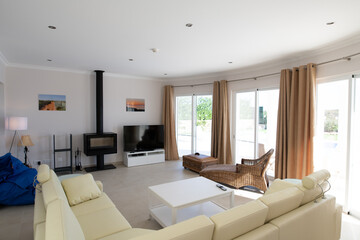 Modern, clean living room of luxury family house with large l-shape leather sofa and tiled floors