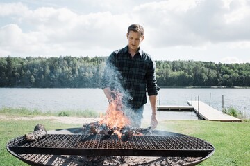 man making a bbq outside at the beach in Sweden