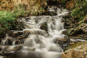 Waterfall photo. Long exposure photo of a beautiful wild waterfall. Motion blurr water in a mountain creek in deep forest. Hiking in a nature reserve.Fresh clean water.Mountain clean fresh stream.