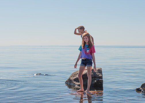 Two Young Girls on Rocky Shoreline