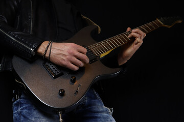 guitarist plays an electric guitar solo with a pick on black background
