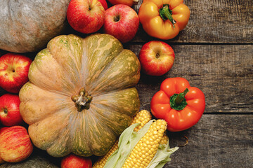 Pumpkins and red apples on wooden background