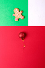 Christmas geometric background in red, green and white. Gingerbread cookie and bauble. Colorful flat lay
