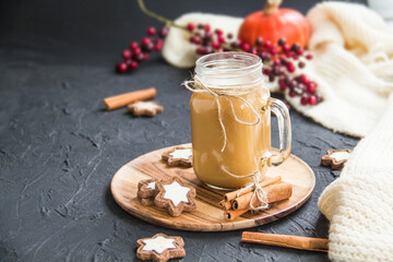 Pumpkin spiced latte or coffee in a cup on turquoise vintage background. Autumn, fall, or winter hot drink. Cozy breakfast or snack.
