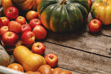 Autumn harvest of pumpkins and apples on wooden board