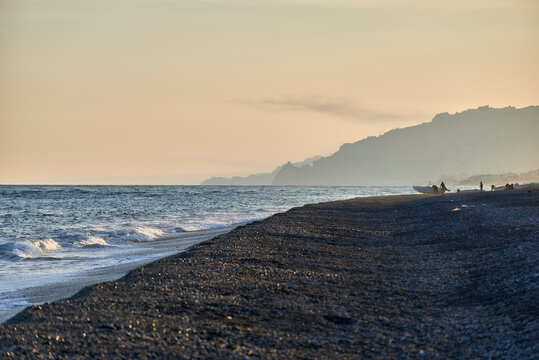 detail of the sea waves in the warm hour of sunset on the coast of Sicily near Taormina