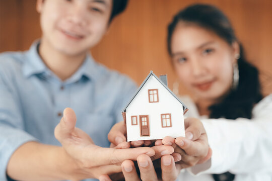 Young couple showing house model.