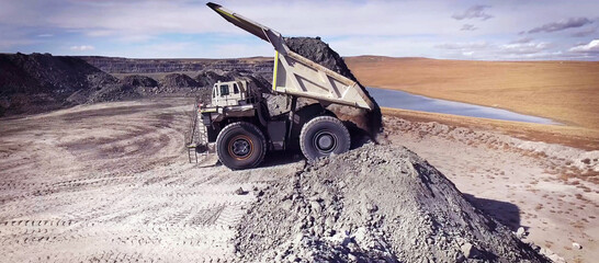 Haul truck unloading soil in quarry