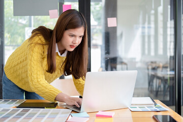 Young photographer and graphic designer at work in office.