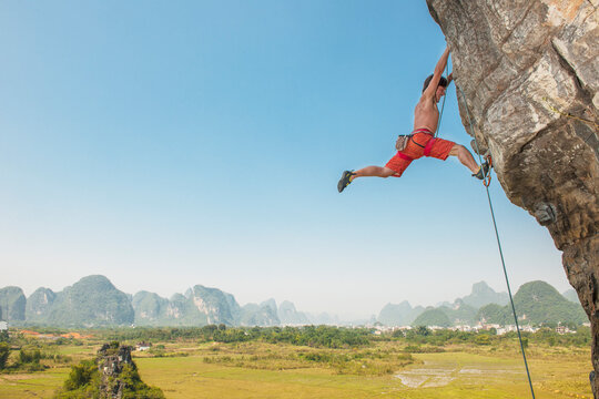 male climber pulling up on overhanging rock in Yangshuo / China