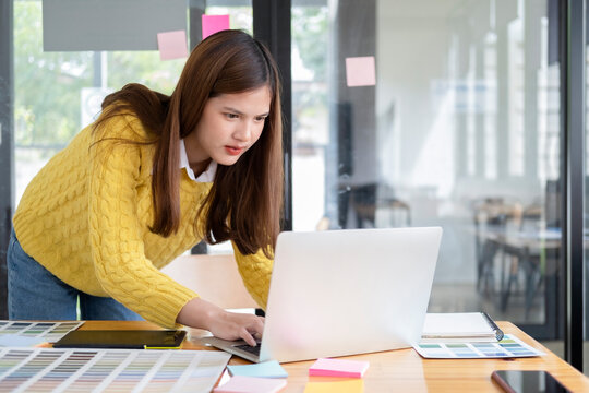 Young photographer and graphic designer at work in office. - Powered by Adobe