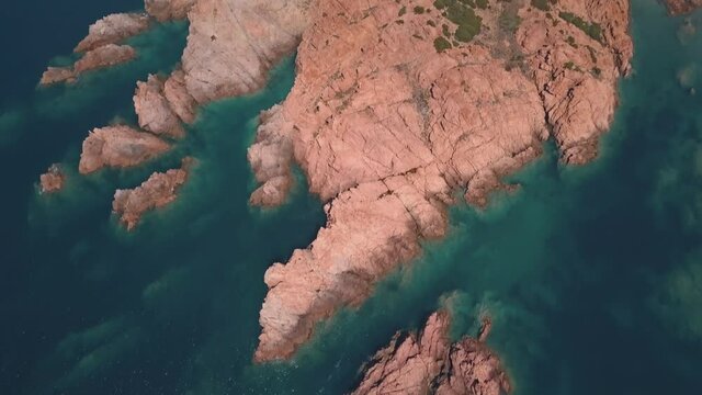 Aerial view of a reddish remote reef near Isola Rossa, Sardinia, Italy.