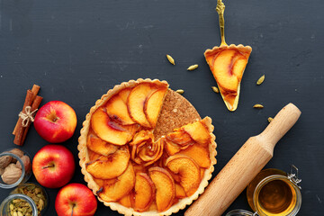 Apple tart pie and red apples on wooden table