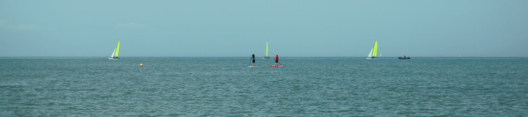 Voiliers et paddle en bord de mer