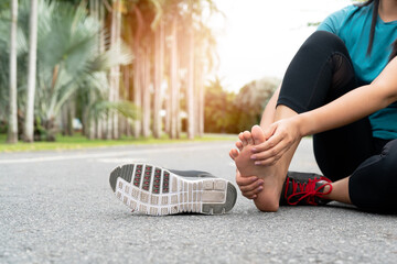 Asia woman massaging her painful foot while exercising. Running