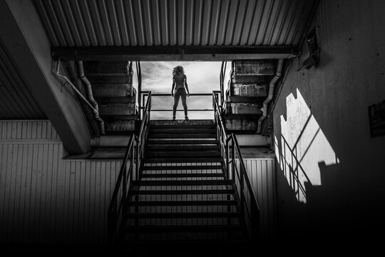 Sporty woman relaxing on the stairs of stadium in black and white