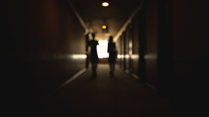 Back view of Caucasian young couple walking hotel hallway