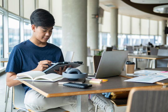 Young collage student using computer and mobile device studying