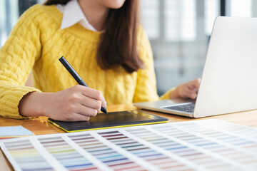 Young photographer and graphic designer at work in office.