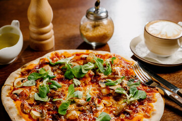 Mushroom pizza with addition mozzarella cheese and herbs on a wooden table, top view